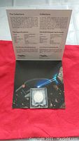 Open package showing Certificate of Authenticity with a silver coin in sealed plastic holder.