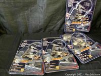 Four BBQ grill lights in original packaging, each with a flexible neck and clip, arranged on a dark surface.