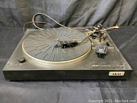 Front angle view of Akai AP-B20 record player turntable showing platter, tonearm, and controls.