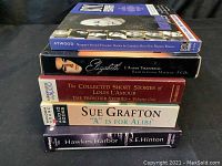 Stack of 5 audio books showing titles and authors visually