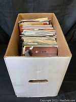 Full view of the white cardboard box filled with magazines, arranged vertically.