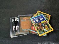 Stack of Magic: The Gathering cards with some in protective sleeves, alongside Tales from the Crypt cards.
