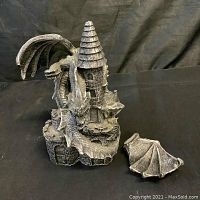 Photo showing the dragon coiled around the castle tower with the detached dragon wing next to the base.