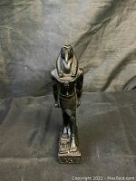 Front view of black resin statue of Thoth standing on hieroglyphic base