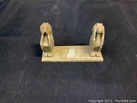 Front view of a brass or bronze paperweight showing two monkeys side by side on a rectangular base, one covering its eyes and one covering its ears.