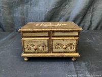 Front view of vintage music player jewelry box with two small drawers and carved decorations