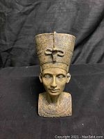 Front view of Nefertiti statue bust showing detailed face, crown, and collar.