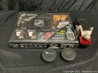 Photo of NHL playing cards box, two hockey pucks, and Harley Davidson plush toy