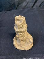 Front view of a real sand castle statue with windows and stairs on a sand base