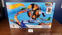 Front view of unopened Hot Wheels Action Spinwheel Challenge box displaying track loop, spinwheel mechanism, launcher, and cars on the packaging.