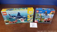 Photo of two LEGO sets boxed: Creator Deep Sea Creatures 31088 and City Barbecue Burn Out 60212.