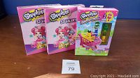 Photo showing the Shopkins Kinstructions Shopping Cart playset box alongside two boxes of 32 Valentine-themed Shopkins cards each.