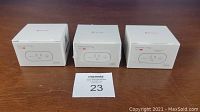 Three boxed smart plug units on a table with numbered tagging card.