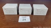 Three boxed Teckin SP20 15A Smart Wi-fi Plugs arranged side by side on a wooden surface with a lot tag in front.