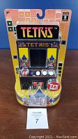 Photo of the front of the miniature Tetris arcade game in its original packaging with the Try Me button visible and colorful Tetris branding.