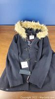 Front view of navy women's winter jacket with fur-trimmed hood and toggle closures.