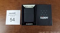 Zippo lighter in original black box with foam insert, includes a 'Made in USA' label showing origin.