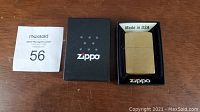 Zippo brushed brass lighter displayed in original black Zippo box with foam insert and 'Made in USA' label.