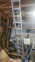Aluminum extension ladder leaning against garage wall showing entire length and pulley system