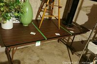 Full view of folding table with metal legs in basement setting, showing size and condition.
