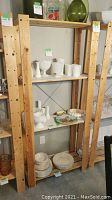 Full view of the wooden shelf rack showing structure and shelves with various white ceramic pieces on display (not included in sale).