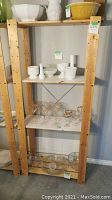 Wooden shelf rack from the front filled with various glass and ceramic items, all contents not included in the sale.