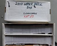White cardboard box with handwritten label '2010 Upper Deck Box 1,600 Cards' on its top, opened to show packed stacks of cards.