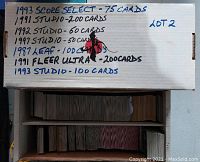 Photo showing a white cardboard box with handwritten label detailing the contents and quantities of baseball cards inside.