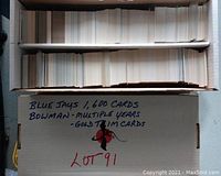 Box with stacks of 1600 Bowman Blue Jays baseball cards with gold trim, labeled on the box.