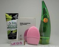 Photo showing the lot consisting of St. Ives Blackhead Clearing Green Tea Scrub tube, pink facial cleansing instrument with box, and Aloe 99 Soothing Gel bottle.