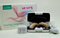 Coniler hearing amplifier box with two beige behind-the-ear hearing amplifiers in a black and white charging case, USB charging cable, and white power adapter arranged in the photo.