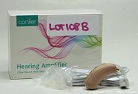 Photo of Coniler hearing amplifier, showing device, ear tips, charging cable and packaging box