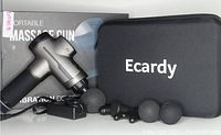 Ecardy massage gun in metallic silver and black with five attachment heads, charging adapter, and carrying case on display.