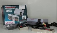 Mini Anniversary Entertainment System console with original box, two wired controllers, and AV cables.
