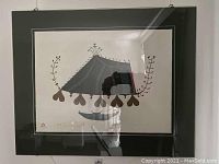 Framed lithograph artwork showing a stylized tent with organic decorative motifs in earthy colors on a light background, with black matting around the print.