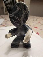 Front view of black and white soapstone Drum Dancer sculpture holding drum and stick