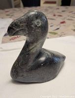 Front view of the hand-carved stone loon bird sculpture showing bird detail and stone texture.