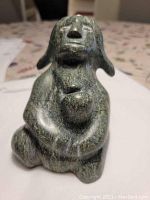 Front view of the carved soapstone sculpture depicting a woman holding a child, showing the shape and details of the figures.