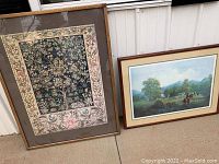 Three framed artworks leaning against exterior porch siding. The large framed floral piece is on the left with two smaller vintage hunt themed prints on the right.