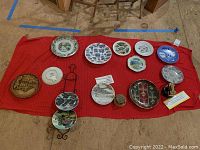 Multiple collector plates arranged on red cloth on the floor with a metal plate stand among them