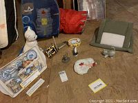 Wide view of all items in the lot showing the tray, figurines, scratching post, tent, tunnel, and bowl