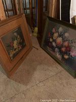 Two framed floral artworks, one with green frame signed by Judith Balogh and one in wooden frame.