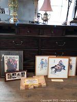 Framed Rockwell artwork arranged on a surface, including Saturday Evening Post cover, Four Seasons prints, Four Freedoms compilation, and collectible plates in original boxes.