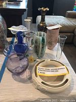 Nine assorted vintage vases displayed on table including Goebel Western Germany pansy ring vase.