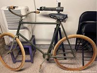 Overall side view of bicycle on repair stand showing frame, rims, grips, saddle