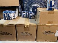 Three large cardboard boxes labeled 'LED Lamp' with multiple TCP LED retail boxes on top