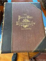 Front cover of The Poetical Works of Henry Wadsworth Longfellow Illustrated Volume II, showing gold embossed title on reddish-brown cloth cover with dark leather spine and corners.