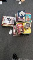 Two stacks of assorted children's and teen books on a carpeted floor.
