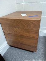 End table showing closed two drawers and wood grain finish