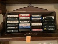 21 assorted 8-track cassettes arranged horizontally in their case, showing various artists and labels including MCA and FDI brands